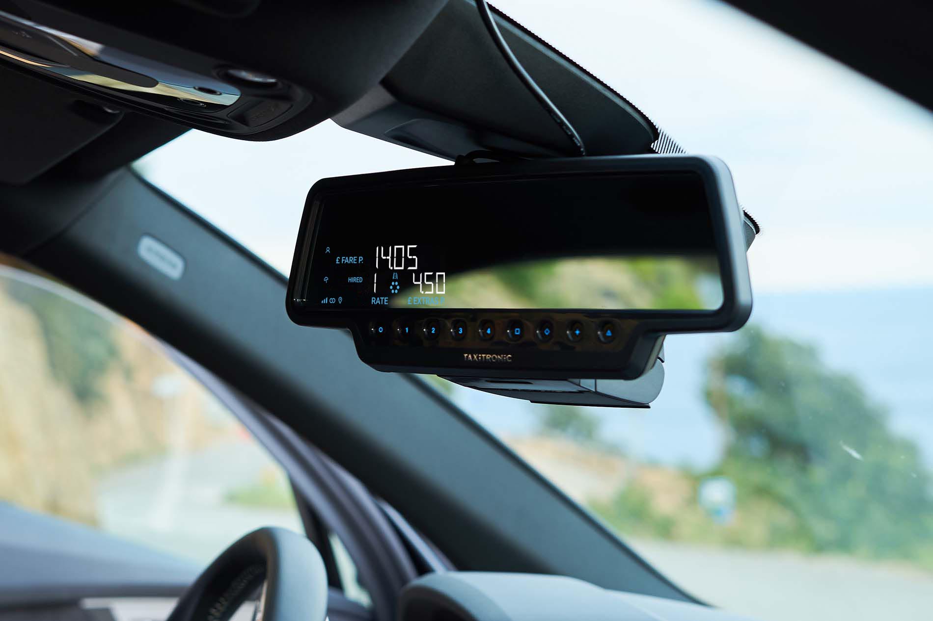 Taxameter met groen ijkingsvignet aan boord van een Vlaamse taxi